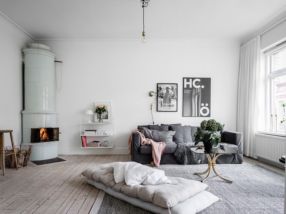 Inspiration för ett stort skandinaviskt separat vardagsrum, med vita väggar, ljust trägolv och en öppen vedspis