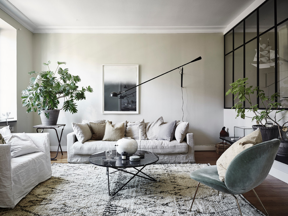 Mittelgroßes, Fernseherloses, Abgetrenntes Skandinavisches Wohnzimmer mit beiger Wandfarbe und dunklem Holzboden in Göteborg