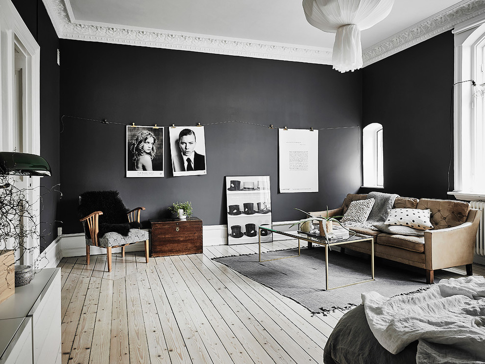 Minimalistisk inredning av ett mellanstort separat vardagsrum, med ett finrum, svarta väggar och ljust trägolv