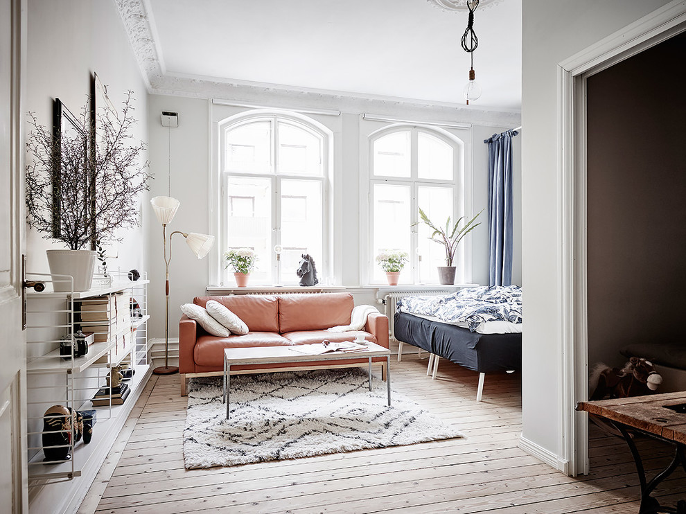 Small victorian open plan living room in Gothenburg with white walls, light hardwood flooring and beige floors.