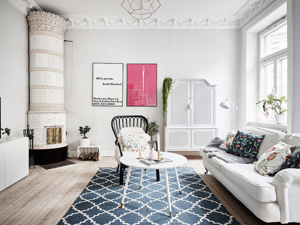 На фото: изолированная гостиная комната среднего размера в скандинавском стиле с светлым паркетным полом, угловым камином, фасадом камина из плитки, бежевым полом и серыми стенами с