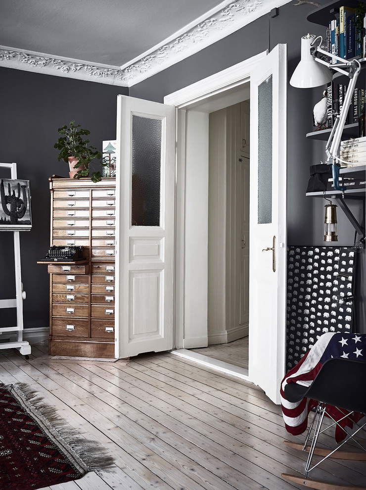 Cette photo montre un salon scandinave avec un mur gris et parquet clair.