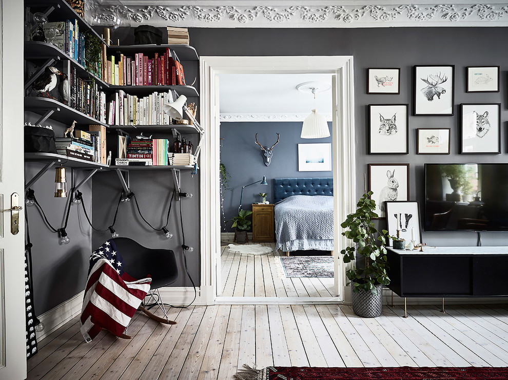 Inredning av ett skandinaviskt mellanstort separat vardagsrum, med ett bibliotek, grå väggar och en väggmonterad TV