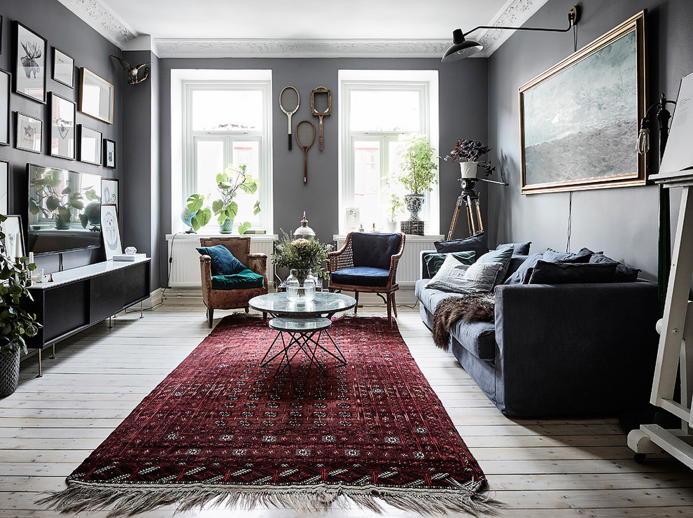Bild på ett minimalistiskt separat vardagsrum, med grå väggar, ljust trägolv, en väggmonterad TV och beiget golv
