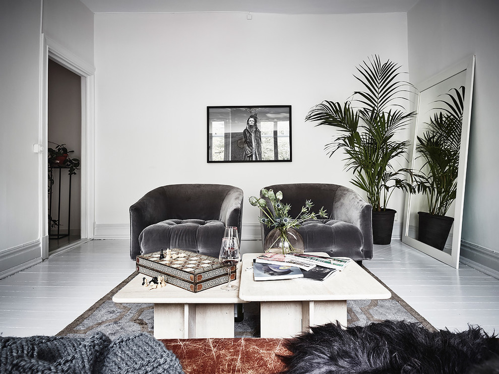 This is an example of a large scandi enclosed living room in Gothenburg with white walls, painted wood flooring and no fireplace.