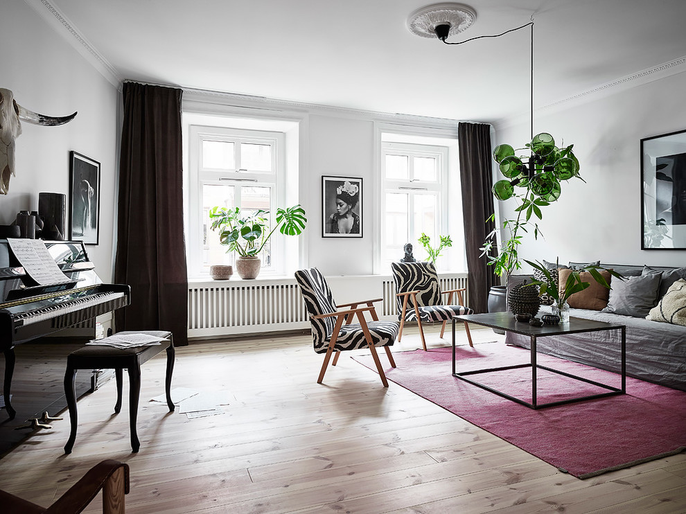 Design ideas for a contemporary enclosed living room in Gothenburg with a music area, white walls, light hardwood flooring and no fireplace.