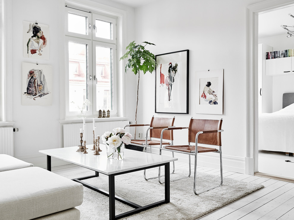 Aménagement d'un petit salon scandinave avec un mur blanc, parquet clair, une salle de réception et aucune cheminée.