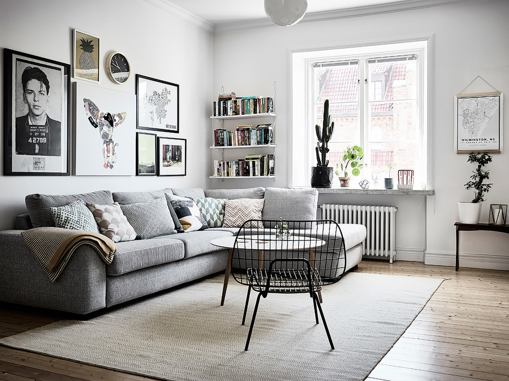 Exempel på ett minimalistiskt vardagsrum, med vita väggar, ljust trägolv och beiget golv