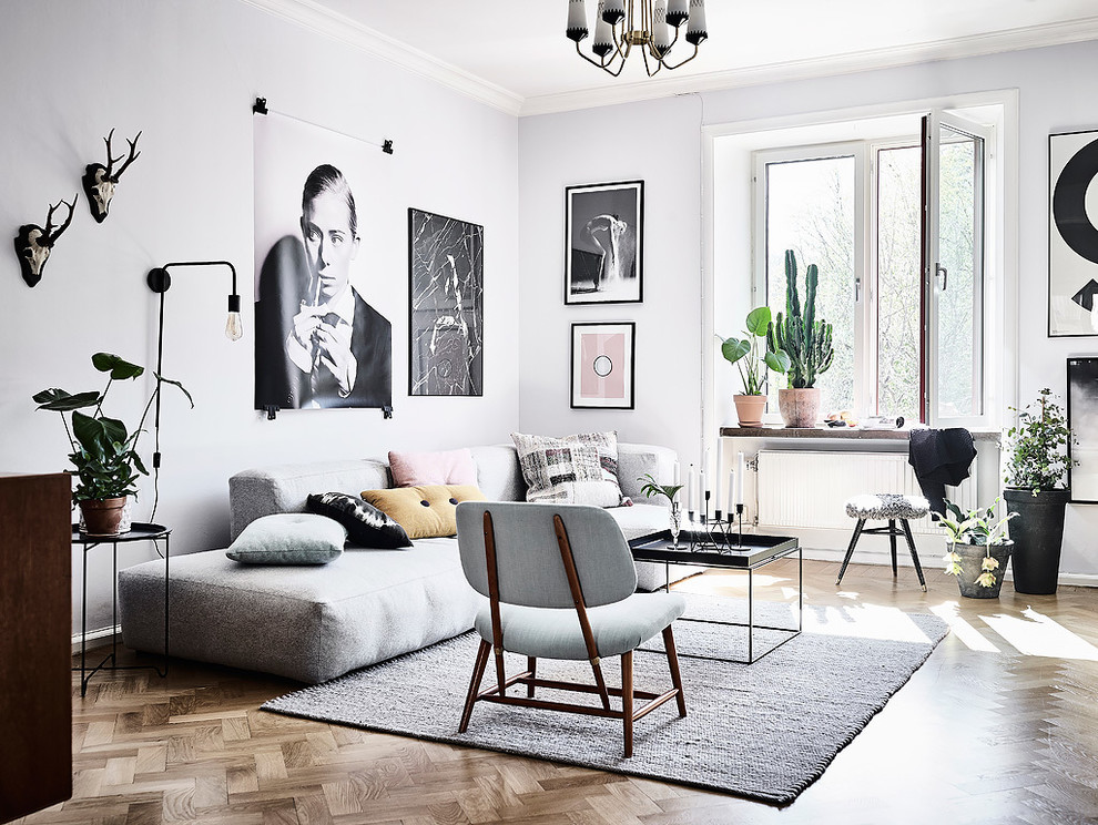 Diseño de salón para visitas escandinavo sin chimenea con paredes grises y suelo de madera clara