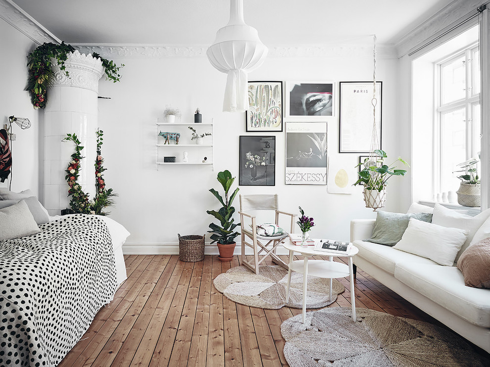 Réalisation d'un salon victorien de taille moyenne avec un mur blanc, parquet clair, un poêle à bois, un manteau de cheminée en carrelage et un sol marron.