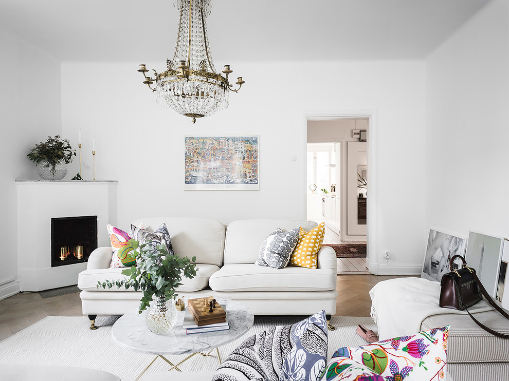 На фото: изолированная гостиная комната в стиле неоклассика (современная классика) с белыми стенами, светлым паркетным полом и угловым камином