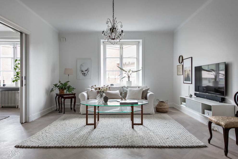 Источник вдохновения для домашнего уюта: парадная гостиная комната в скандинавском стиле с белыми стенами, паркетным полом среднего тона, телевизором на стене и коричневым полом