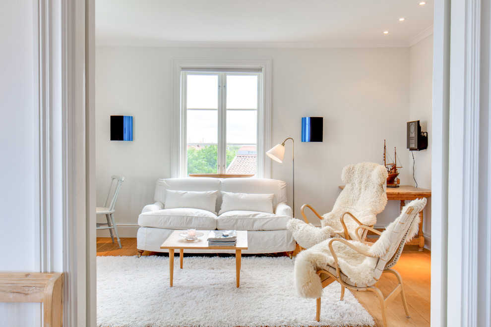 На фото: парадная гостиная комната среднего размера в скандинавском стиле с белыми стенами и светлым паркетным полом без телевизора с