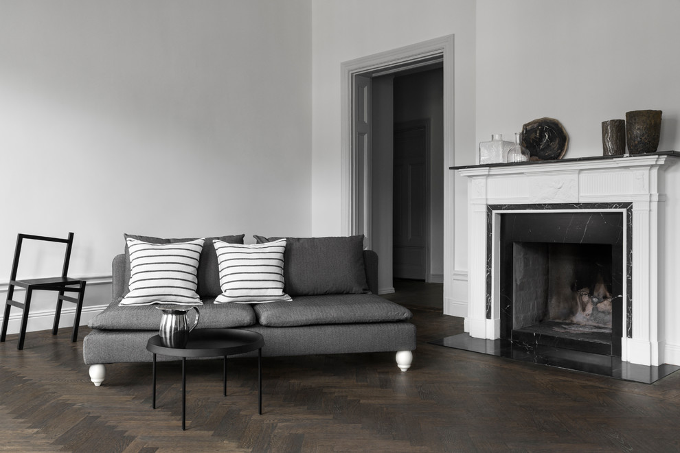 Cette image montre un grand salon nordique avec un mur gris, parquet foncé et un sol marron.