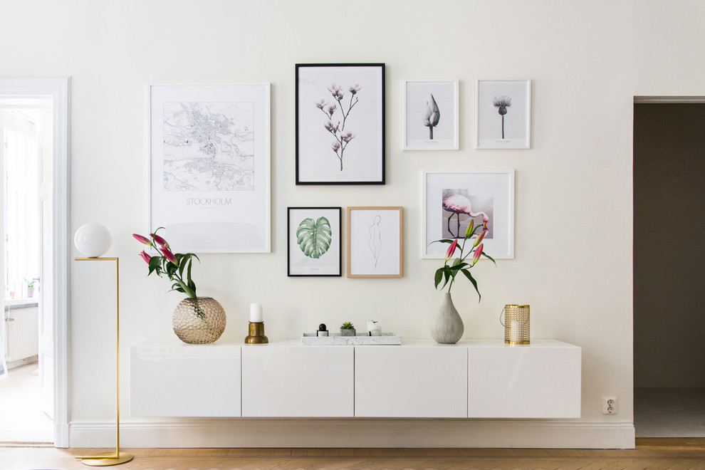 Example of a mid-sized danish formal medium tone wood floor living room design in Stockholm with white walls, no fireplace and no tv