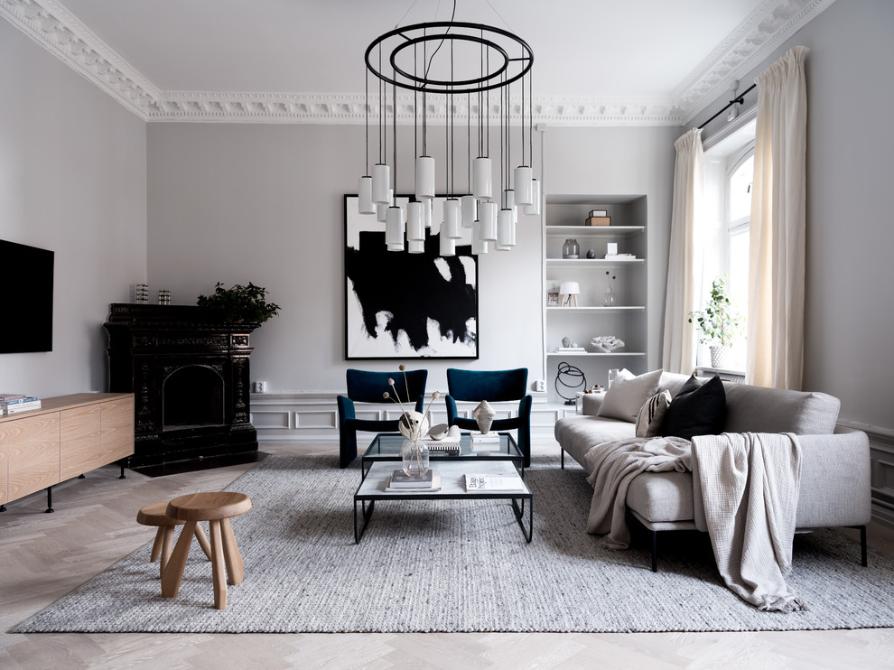 Photo of a contemporary living room in Stockholm with grey walls, light hardwood flooring, a corner fireplace, a wall mounted tv and grey floors.