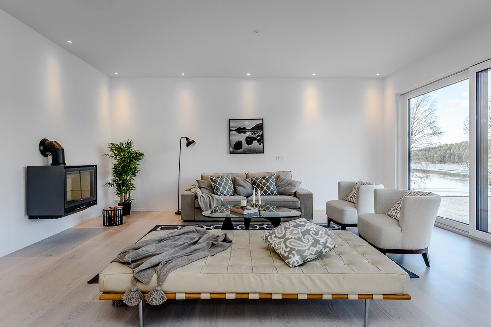 Foto di un soggiorno nordico di medie dimensioni con pareti bianche, parquet chiaro e pavimento beige