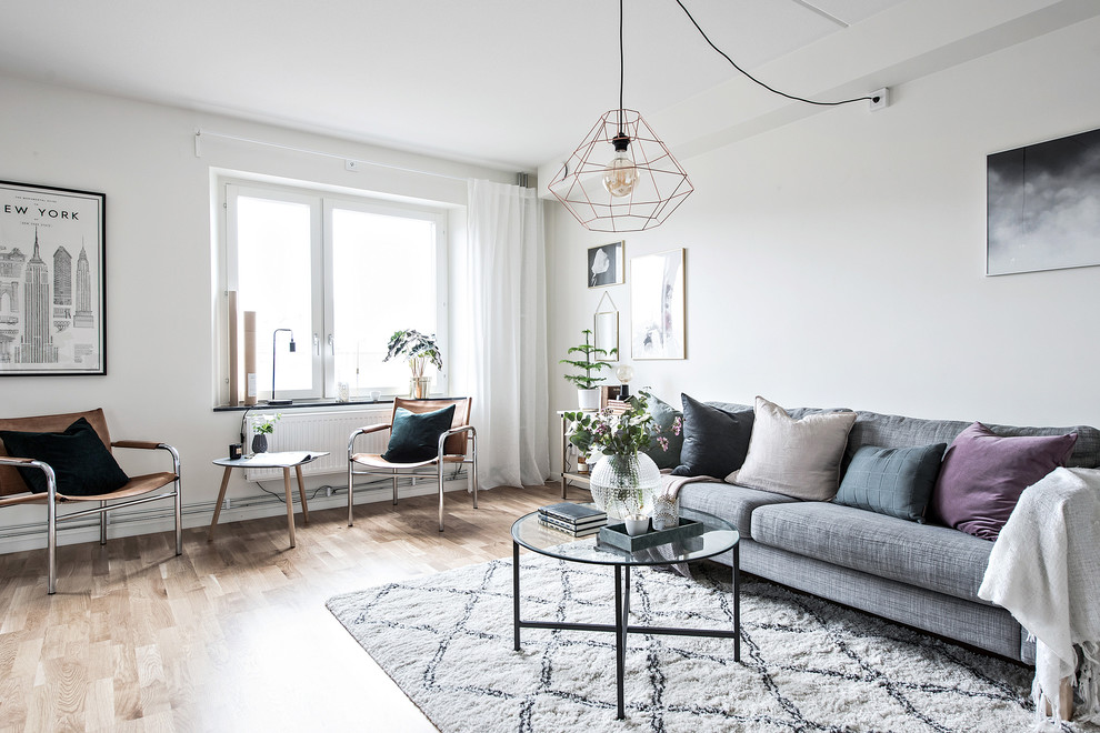 Foto på ett minimalistiskt separat vardagsrum, med ett finrum, vita väggar, mellanmörkt trägolv och beiget golv