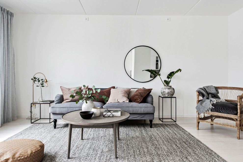 Minimalistisk inredning av ett mellanstort separat vardagsrum, med vita väggar, ljust trägolv och beiget golv