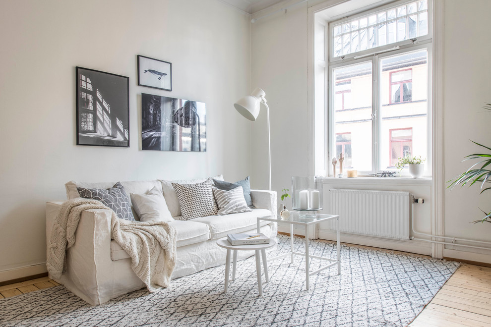Inspiration för minimalistiska vardagsrum, med vita väggar, ljust trägolv och beiget golv