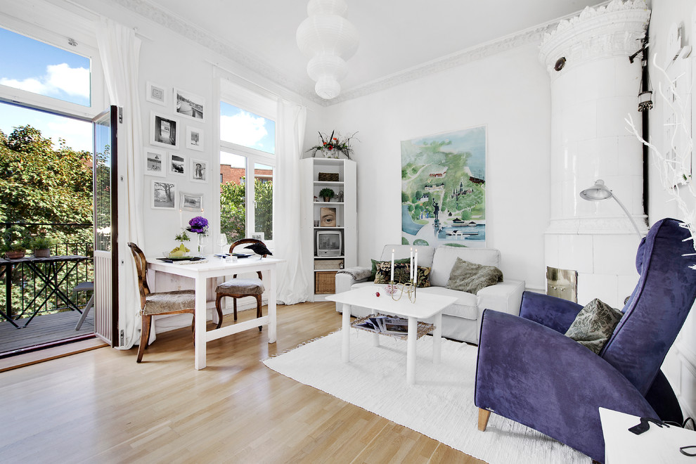 Foto di un soggiorno bohémian di medie dimensioni e aperto con pareti bianche, parquet chiaro, camino ad angolo, sala formale e nessuna TV