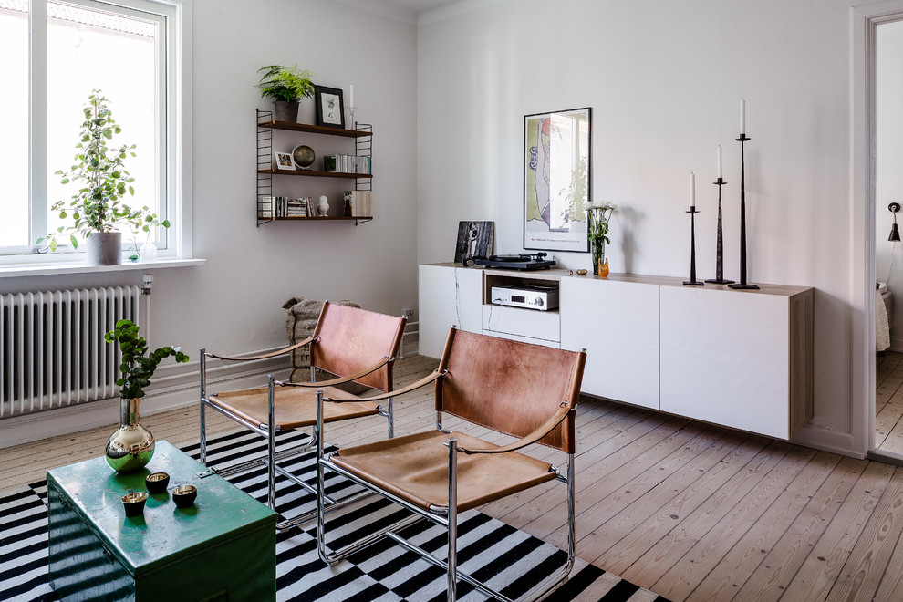 Photo of a medium sized scandinavian formal living room in Gothenburg with white walls, light hardwood flooring and no tv.