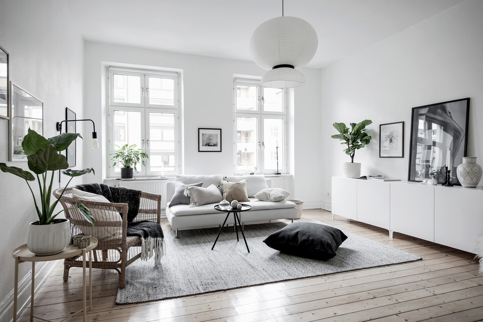 Bild på ett minimalistiskt separat vardagsrum, med ett finrum, vita väggar och ljust trägolv
