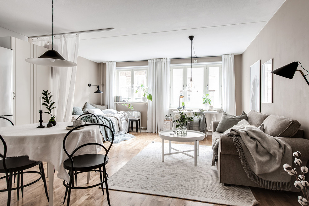 Идея дизайна: открытая гостиная комната в скандинавском стиле с коричневыми стенами, светлым паркетным полом и бежевым полом