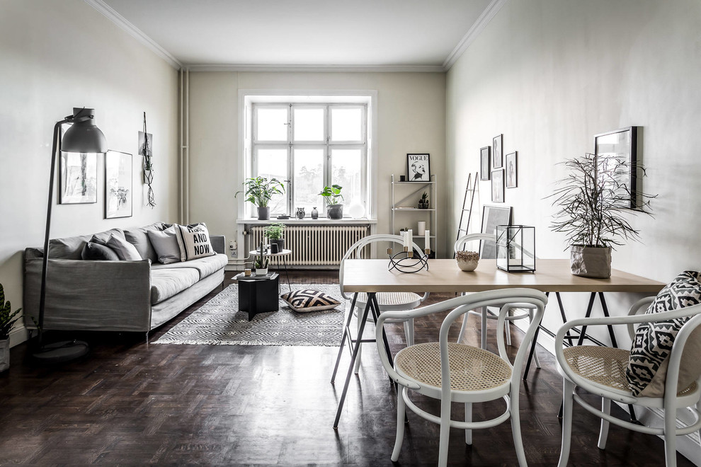 Nordisk inredning av ett mellanstort vardagsrum, med vita väggar, mörkt trägolv och brunt golv