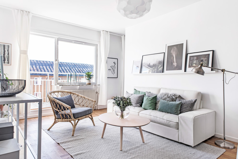 This is an example of a medium sized scandinavian enclosed living room in Stockholm with white walls, medium hardwood flooring and brown floors.