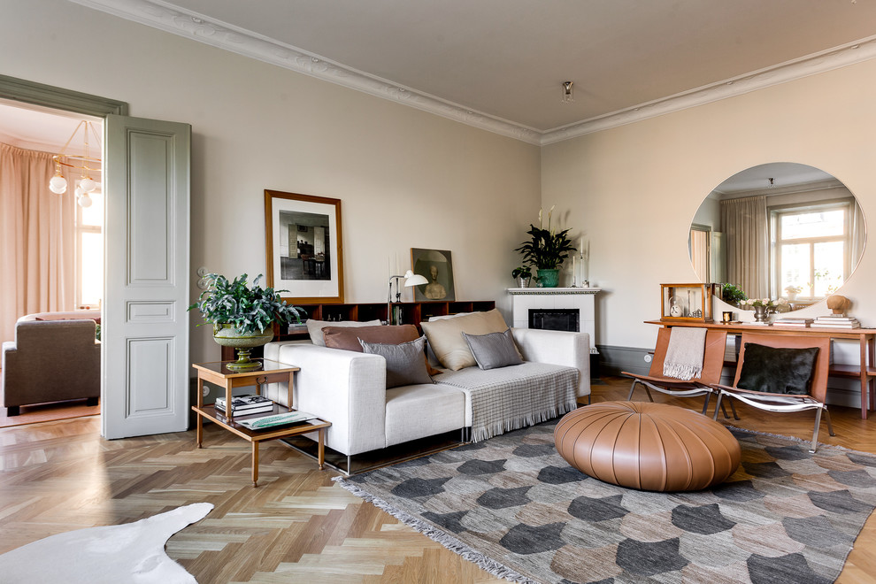 Diseño de salón nórdico de tamaño medio con paredes beige, suelo de madera en tonos medios y chimenea de esquina