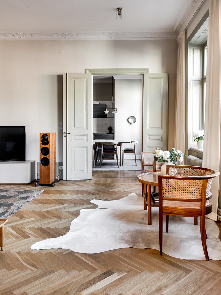 Mittelgroßes, Repräsentatives, Abgetrenntes Skandinavisches Wohnzimmer mit beiger Wandfarbe, hellem Holzboden und freistehendem TV in Stockholm