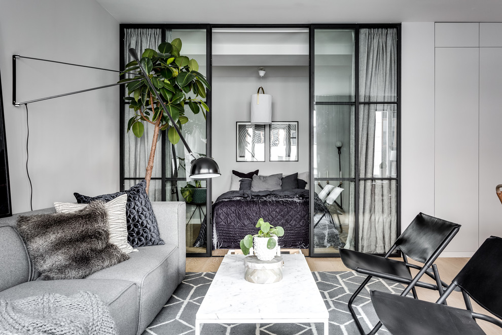 Mittelgroßes, Repräsentatives, Fernseherloses Nordisches Wohnzimmer ohne Kamin mit grauer Wandfarbe und hellem Holzboden in Stockholm