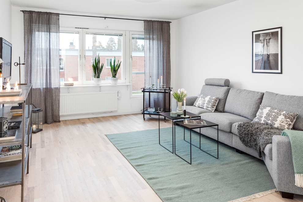 Ispirazione per un soggiorno nordico di medie dimensioni con pareti bianche, pavimento in laminato, TV autoportante e pavimento beige