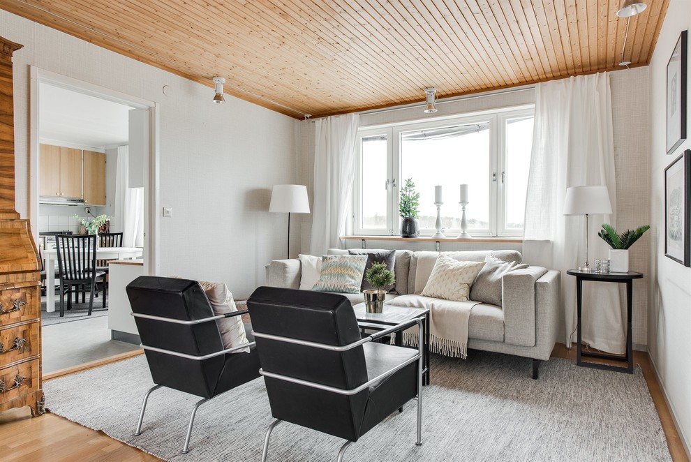 Imagen de salón cerrado escandinavo pequeño sin chimenea con paredes blancas y suelo de madera en tonos medios