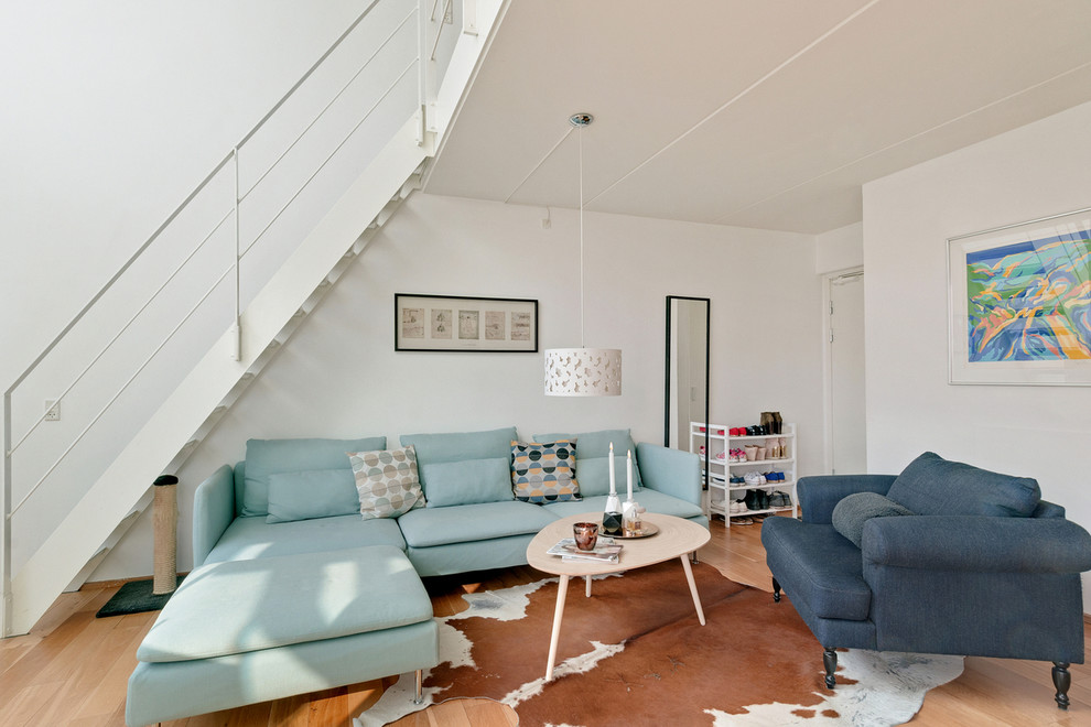 Mittelgroßes, Repräsentatives, Fernseherloses, Abgetrenntes Wohnzimmer ohne Kamin mit weißer Wandfarbe und braunem Holzboden in Kopenhagen