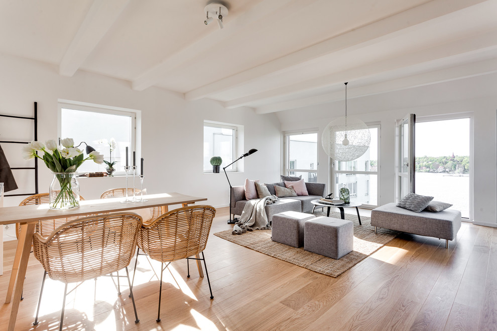 Mittelgroßes, Repräsentatives, Fernseherloses, Offenes Nordisches Wohnzimmer ohne Kamin mit weißer Wandfarbe und braunem Holzboden in Stockholm