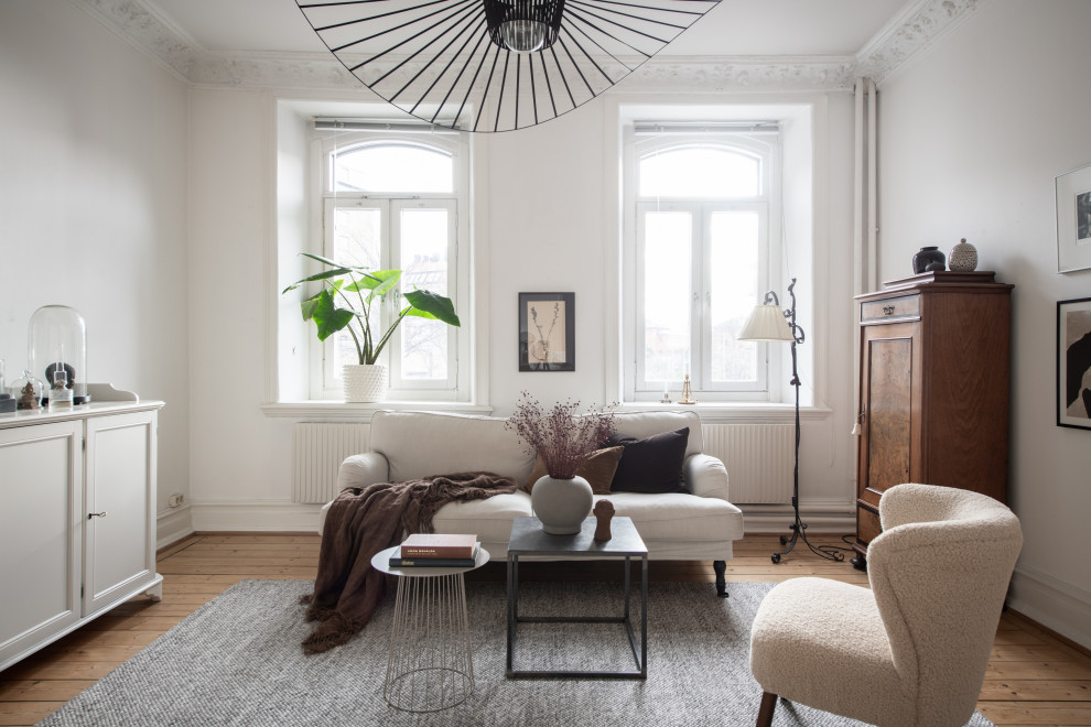 Diseño de salón escandinavo sin chimenea con paredes blancas y suelo de madera clara