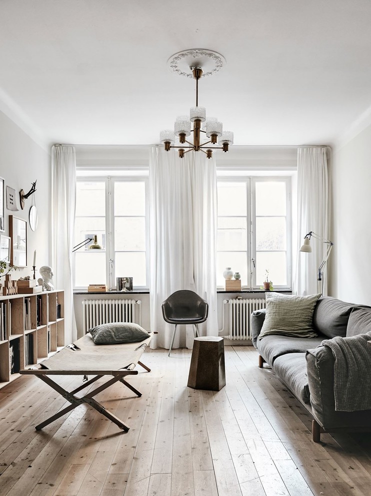 Skandinavisk inredning av ett mellanstort separat vardagsrum, med vita väggar, ljust trägolv, ett finrum och beiget golv