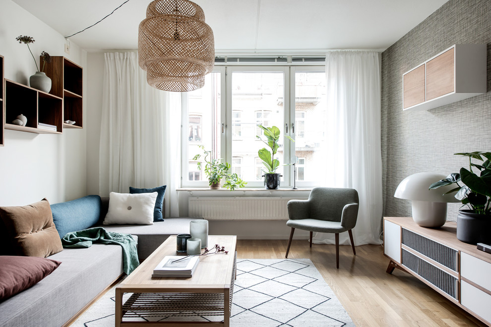 Design ideas for a scandinavian enclosed living room in Gothenburg with white walls, light hardwood flooring and beige floors.