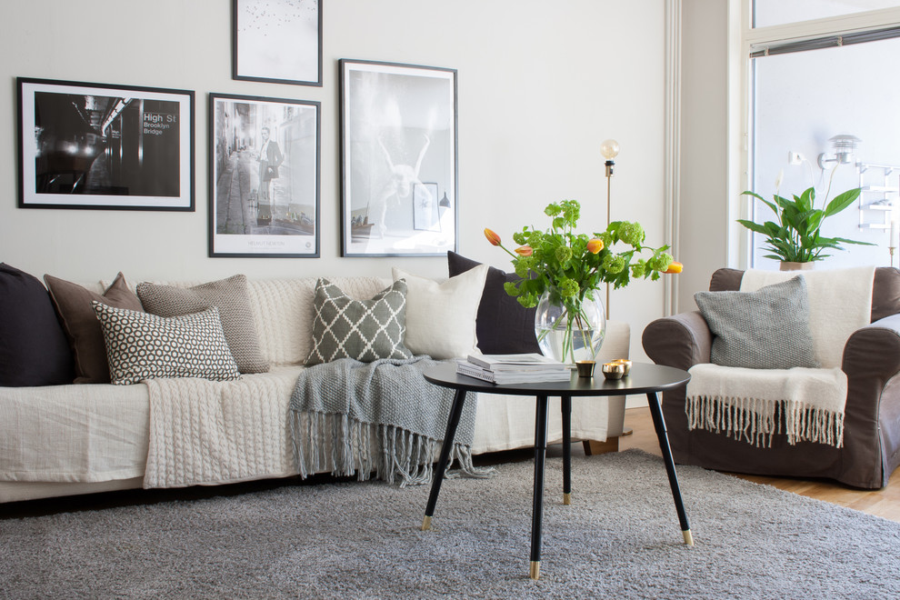 Inspiration for a scandinavian living room in Stockholm with white walls and medium hardwood flooring.