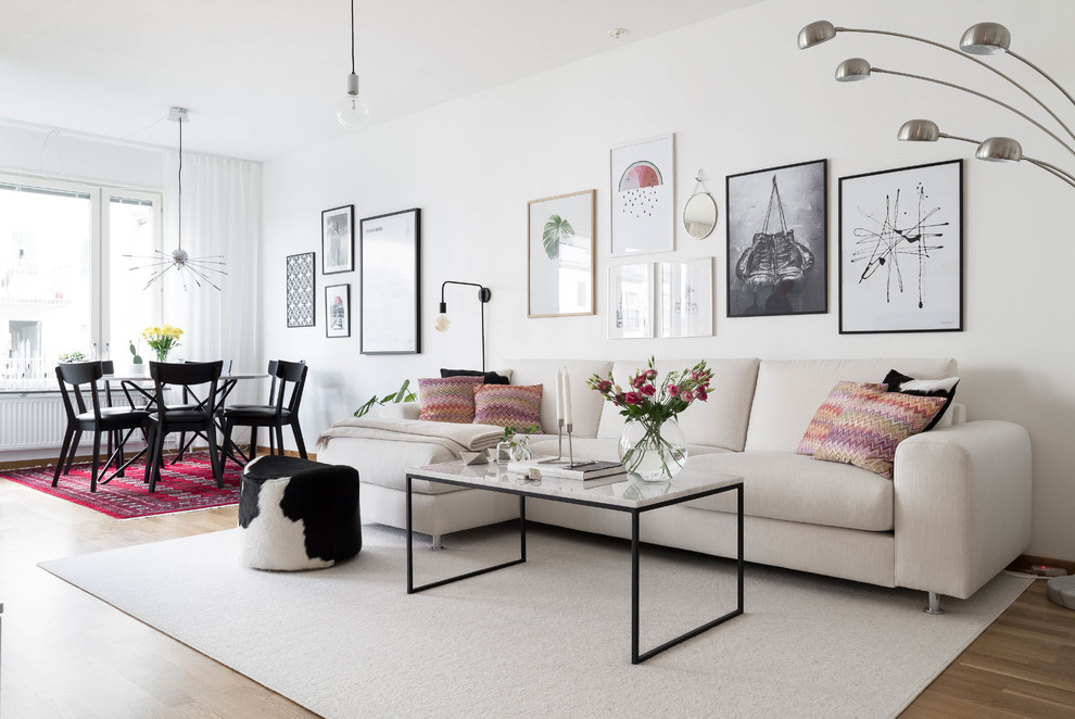Offenes, Mittelgroßes, Repräsentatives, Fernseherloses Nordisches Wohnzimmer mit weißer Wandfarbe und braunem Holzboden in Stockholm