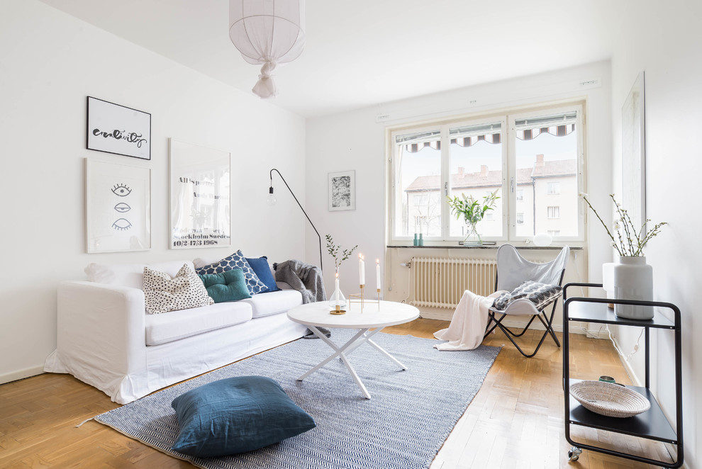 Foto di un soggiorno nordico di medie dimensioni e aperto con pareti bianche, pavimento in legno massello medio, nessuna TV e sala formale