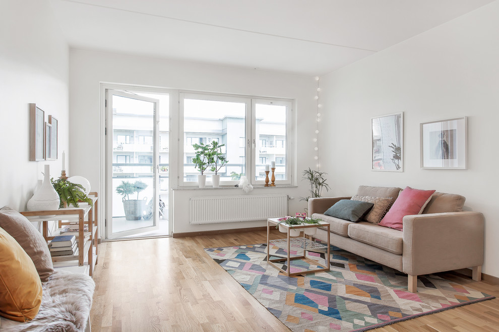 Photo of a medium sized scandinavian formal enclosed living room in Stockholm with white walls, light hardwood flooring, no fireplace and no tv.