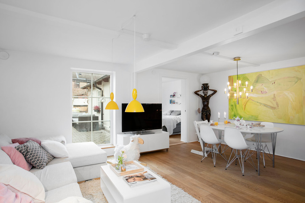 Immagine di un soggiorno moderno di medie dimensioni con pareti bianche e TV autoportante