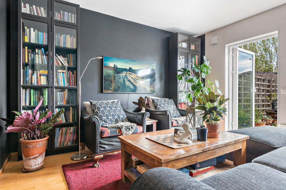 Stilmix Wohnzimmer ohne Kamin mit grauer Wandfarbe, braunem Holzboden, beigem Boden und TV-Wand in Stockholm