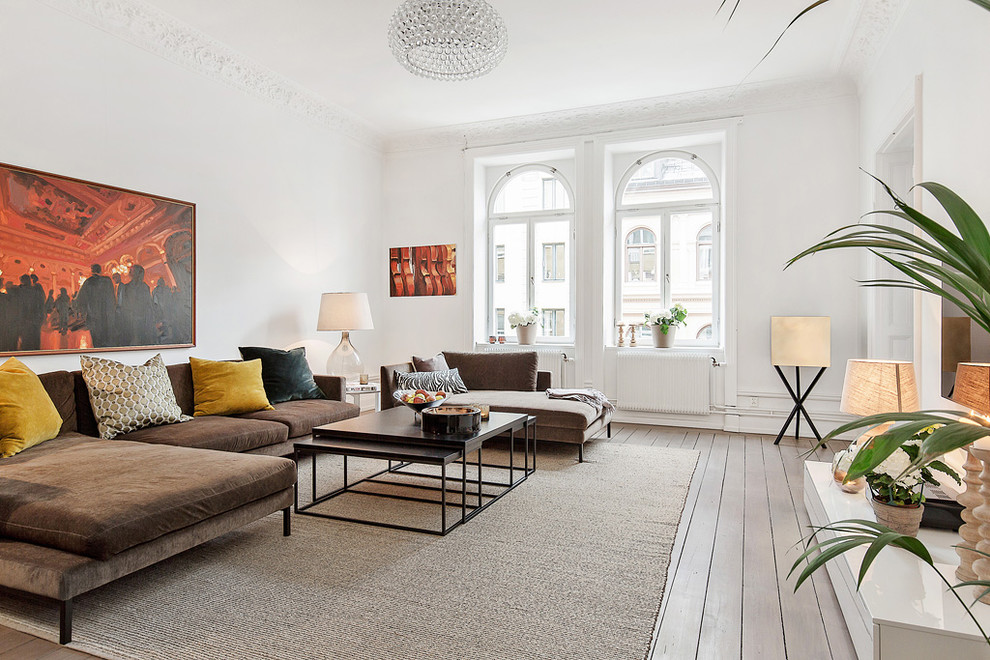 Mittelgroßes, Repräsentatives, Offenes Nordisches Wohnzimmer ohne Kamin mit weißer Wandfarbe, braunem Holzboden und TV-Wand in Stockholm