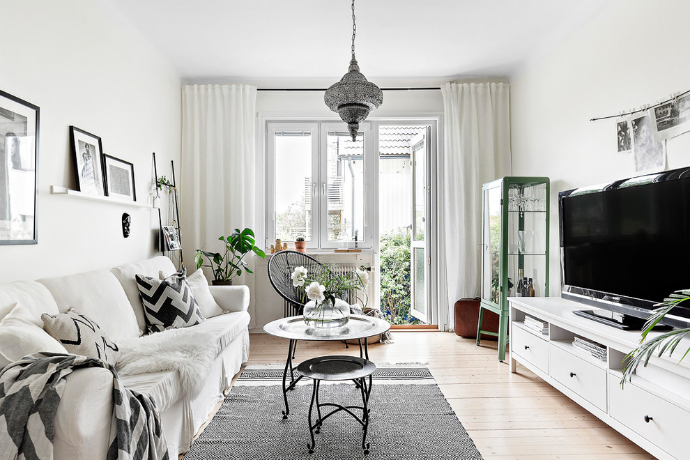 Idéer för att renovera ett mellanstort skandinaviskt separat vardagsrum, med vita väggar, en fristående TV, mellanmörkt trägolv och brunt golv