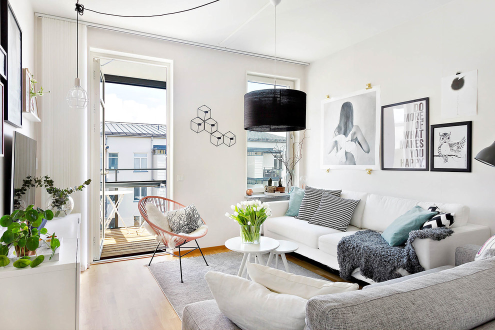 Inspiration for a mid-sized scandinavian formal and enclosed light wood floor living room remodel in Stockholm with white walls and a wall-mounted tv