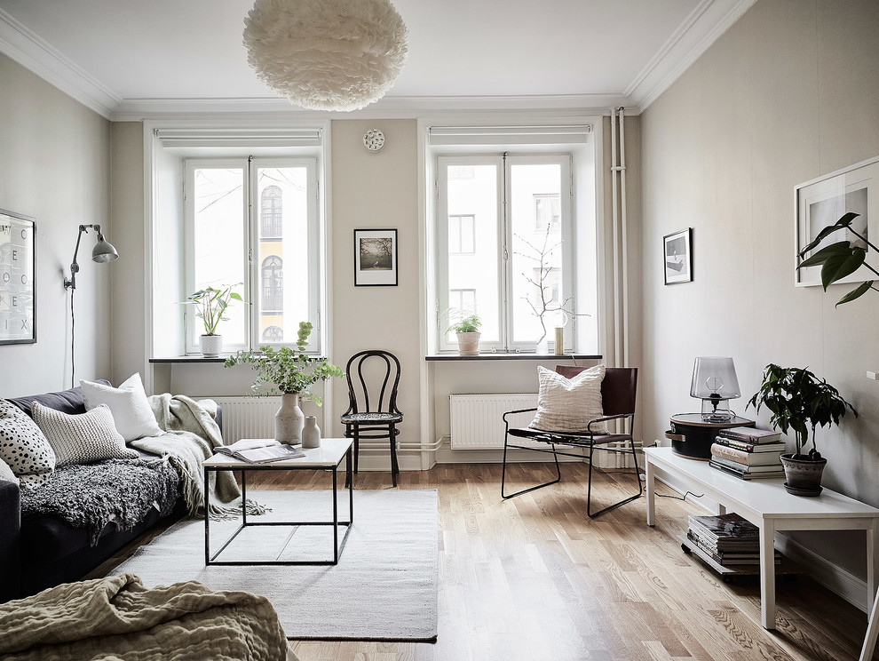 Fernseherloses, Großes, Repräsentatives, Offenes Modernes Wohnzimmer ohne Kamin mit beiger Wandfarbe und braunem Holzboden in Göteborg